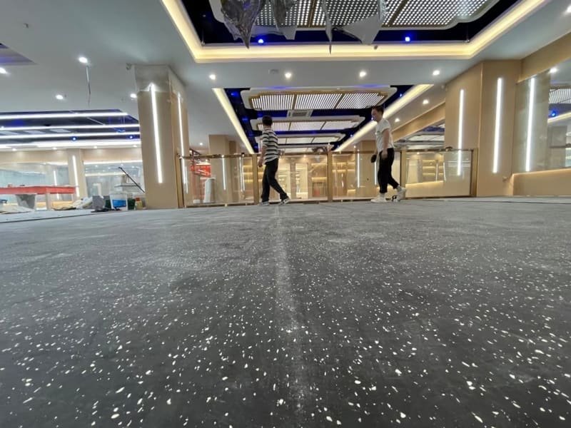 A detailed macro shot showing the clean, tight seam of a waterjet-cut logo in rubber flooring.